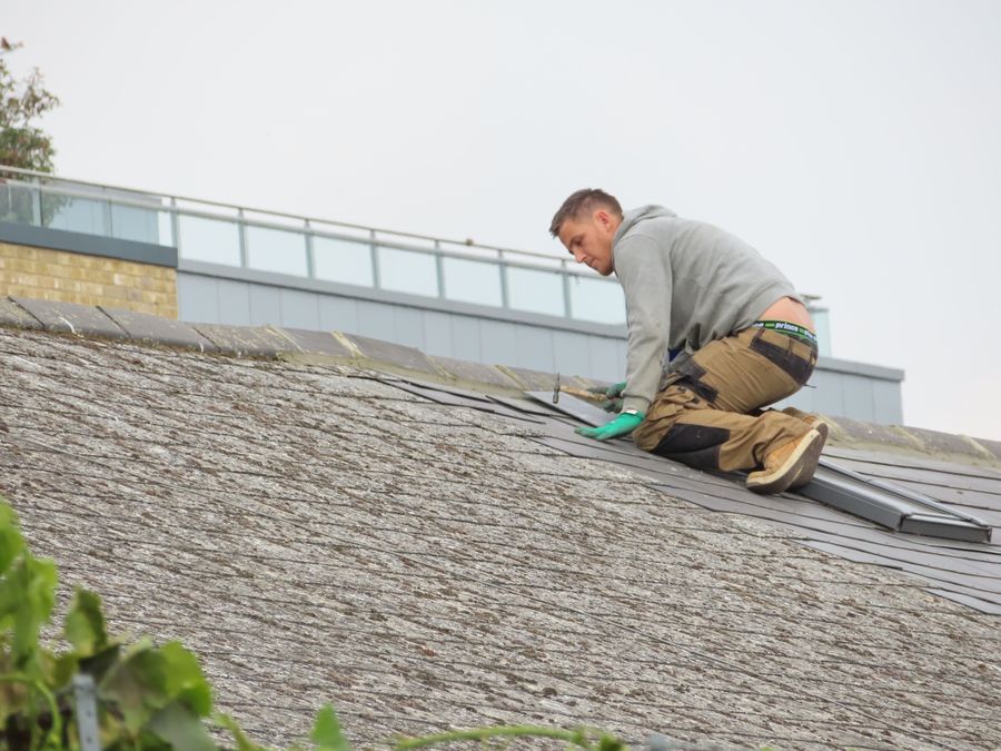 Roofer working on shingle repair