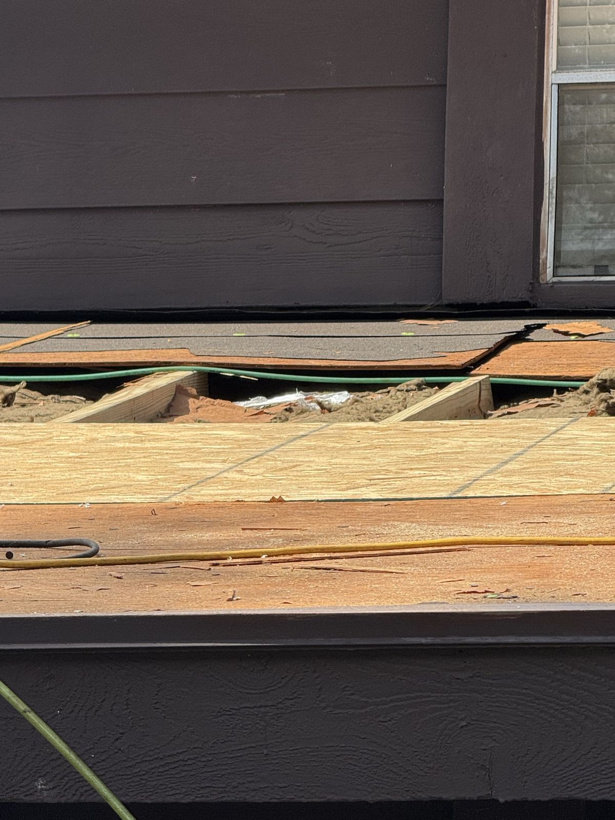 Exposed roof decking during a storm damage repair